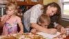 FILE - A mother works with her children during a homeschool assignment in St. Charles, Iowa, Sept. 30, 2011.