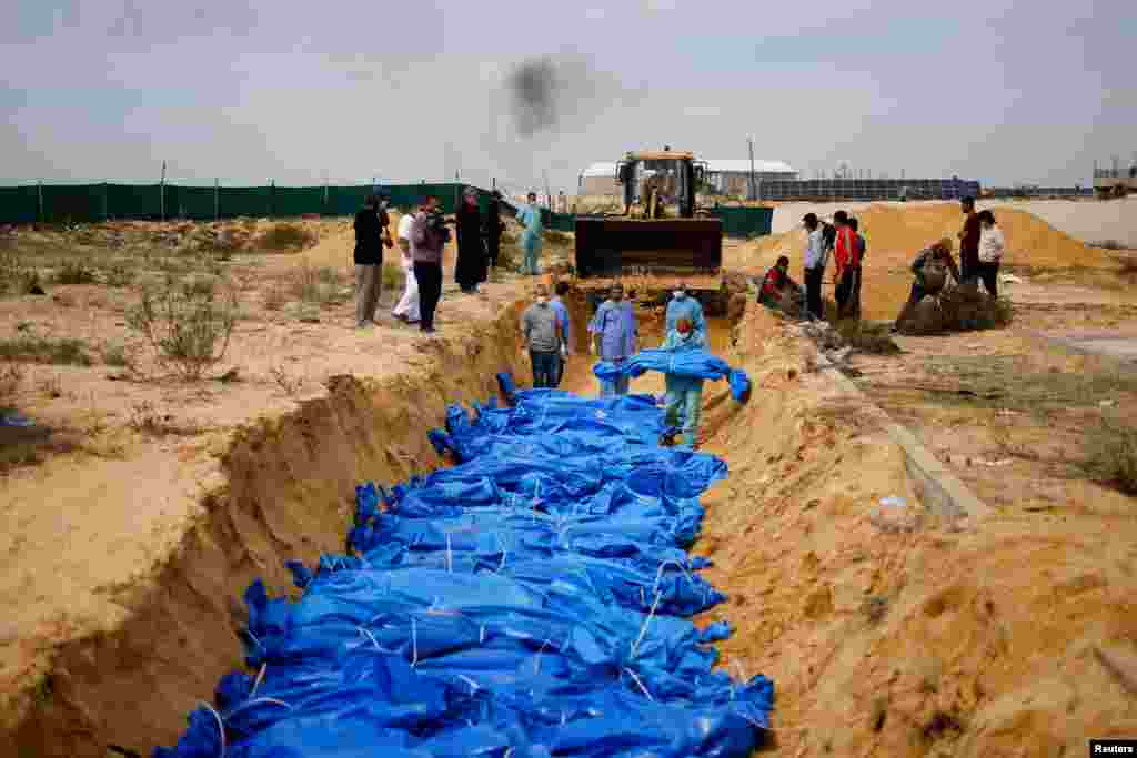 The bodies of Palestinians killed in Israeli strikes and fire are buried in a mass grave, after they were transported from Al Shifa hospital in Gaza City for burial, in Khan Younis in the southern Gaza Strip.