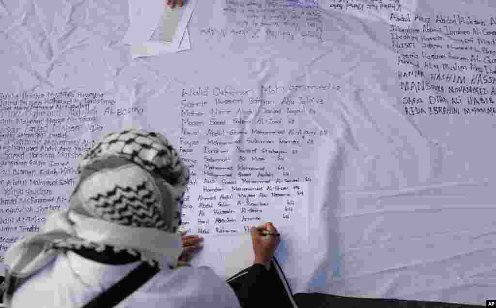 Pro-Palestinian supporters write names of lives lost during the war, as they protest outside Parliament in Cape Town, South Africa. The majority of MPs voted to close the Israeli embassy in South Africa over the war in Gaza. 