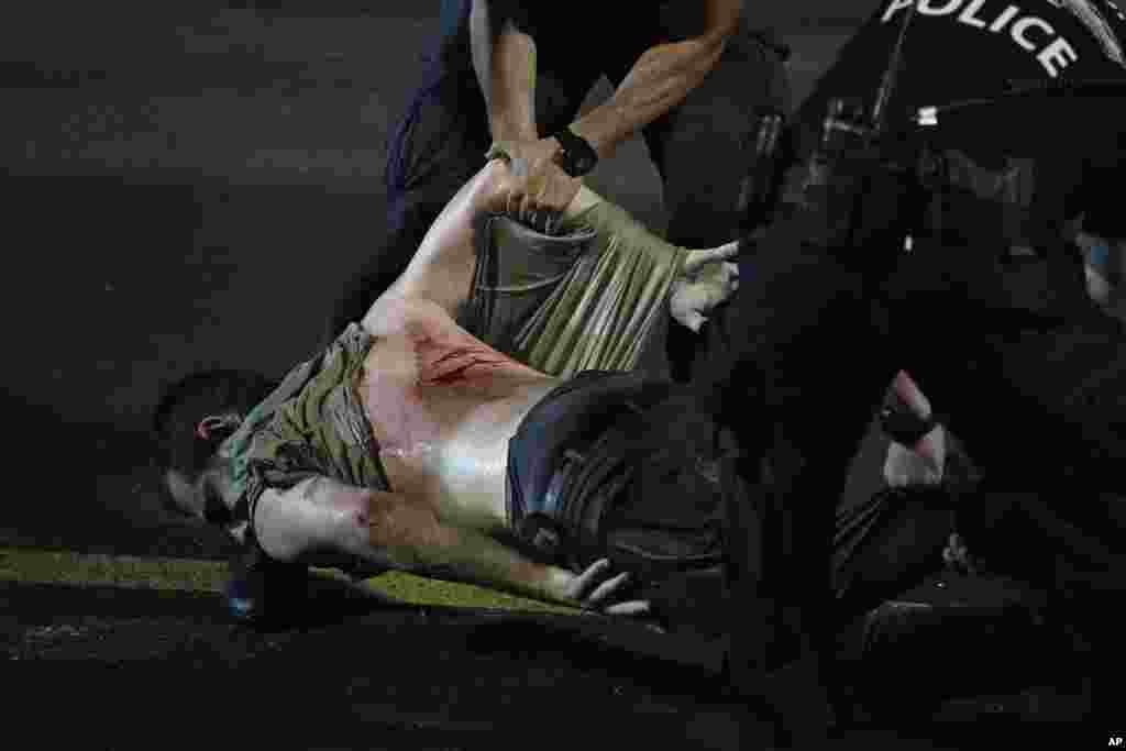 An injured demonstrator is dragged by police to be detained during a protest against plans by Israeli Prime Minister Netanyahu's government to overhaul the judicial system, in Tel Aviv, July 24, 2023.