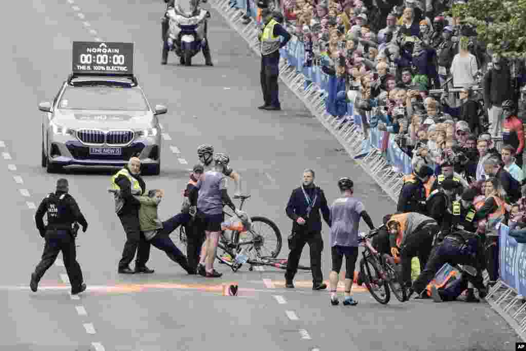 Police remove activists from the track before the start of the Berlin Marathon in Berlin, Germany. Activists from the "Last Generation" block the track of the Berlin Marathon to protest against the climate policies of the government.