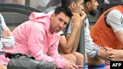 Lionel Messi, kiri, duduk di bangku cadangan saat pertandingan sepak bola persahabatan antara Hong Kong XI dan Inter Miami CF di Hong Kong, 4 Februari 2024. (Foto: AFP)