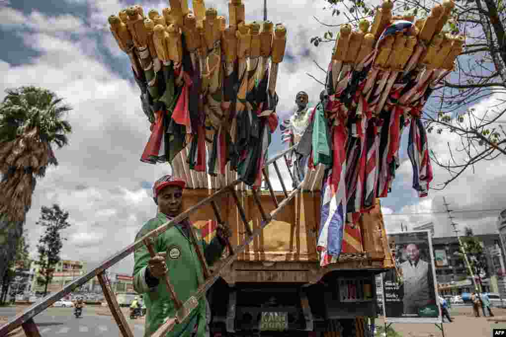 Nairobi City County workers get ready to unload flags of Kenya and the United Kingdom from a truck in Nairobi ahead of the Britain's monarch visit to Kenya.