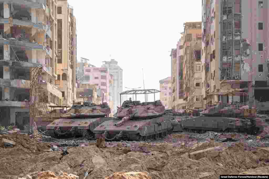Israeli military vehicles take position in the Gaza Strip amid the ongoing ground operation of the Israeli army against Palestinian Islamist group Hamas.