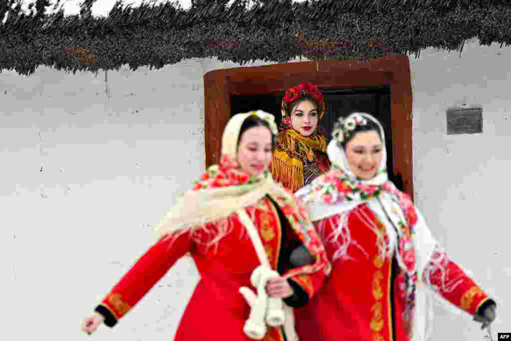 کچان بە پۆشاکی نەریتیی ئۆکرانیاوە بەشداری لە ئاهەنگێکی کرسمس دەکەن لە گوندی پیرۆگۆڤی نزیک کیێڤ، 25 ی 12 ی 2023. 