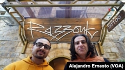 Wassim Rassouk (der) y su hijo Nizar (izq) posan a la entrada del negocio familiar, en el barrio cristiano de la Ciudad Vieja de Jerusalén.