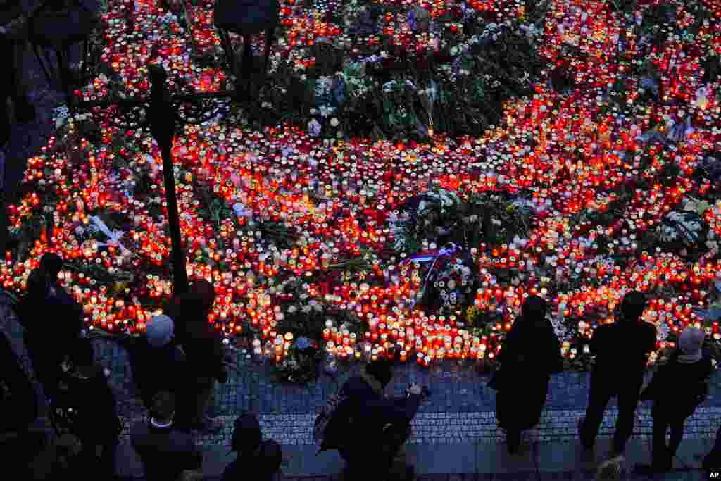 Mourners bring flowers and candles outside the building of Philosophical Faculty of Charles University in Prague, Czech Republic. A lone gunman opened fire at a university on Thursday, killing more than a dozen people.