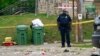 Seorang petugas polisi berdiri di area insiden penembakan massal di Distrik Selatan Baltimore, 2 Juli 2023.