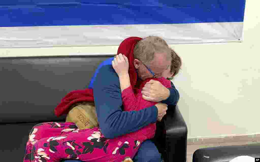 In this photo provided by the Israeli army, Emily Hand, right, a released hostage, reunites with her father, in Israel. The tense cease-fire between Israel and Hamas appeared to be back on track after the release of a second group of militant-held hostages and Palestinian prisoners.