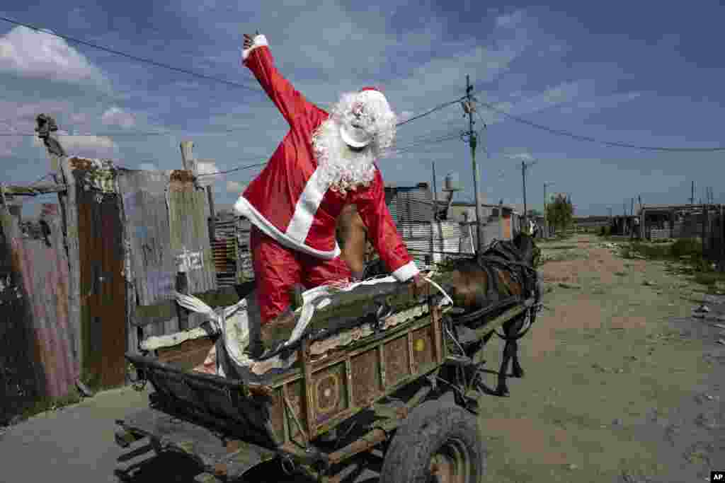 Tito Perez, dressed as Santa Claus, waves to children at a pre-Christmas celebration organized by "Los Chicos de la Via" soup kitchen, in Buenos Aires, Argentina, Dec. 23, 2023.