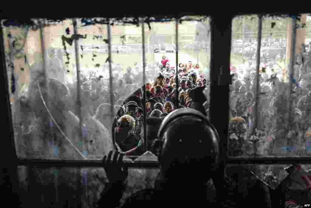 Congolese police officers block a door after voters forced their way into a voting station in Kinshasa, Democratic Republic of Congo. Millions of Congolese head to the polls in a high-stakes general election in which President Felix Tshisekedi is seeking a new term against a fragmented opposition.