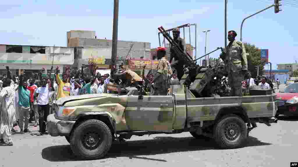 Sudanese greet army soldiers, loyal to army chief Abdel Fattah al-Burhan in the Red Sea city of Port Sudan on April 16, 2023. (AFP) Wasudan wakiwasalimia wanajeshi, ambao wanamuunga mkono Mkuu wa Jeshi Abdel Fattah al-Burhan katika mji wa Red Sea wa Port Sudan Aprili 16, 2023. (AFP)