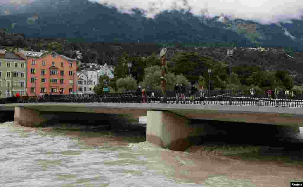 People pass a bridge over the river Inn in the old town of Innsbruck, Austria.
