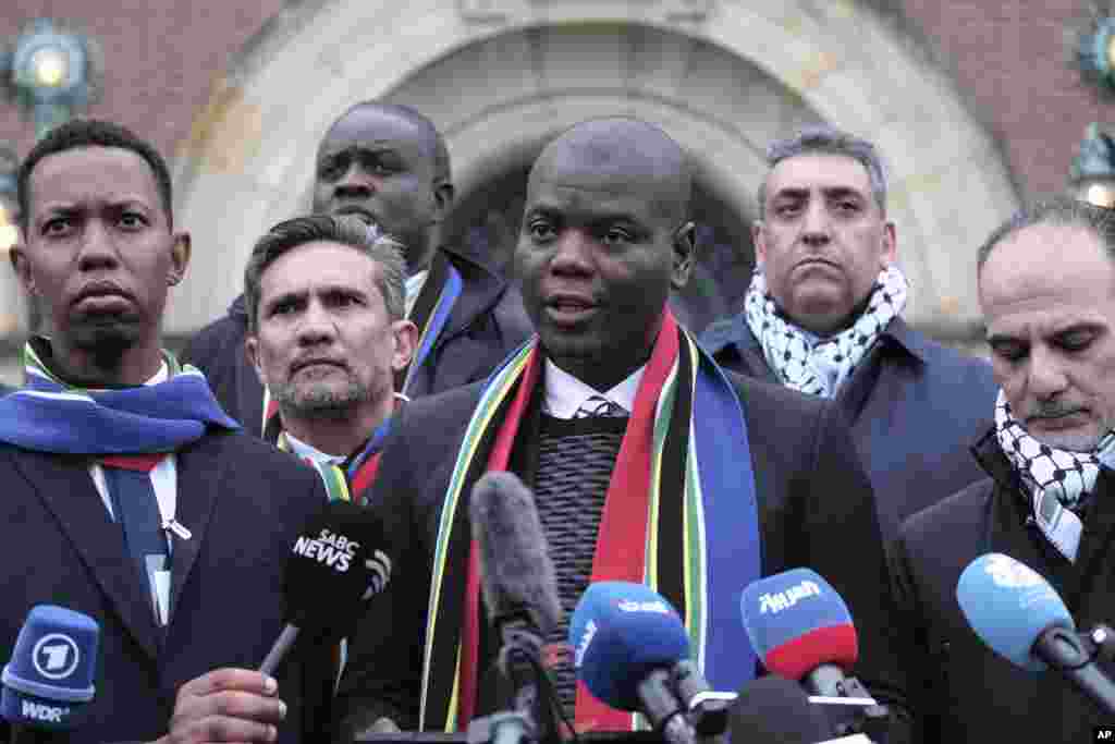 South Africa's Minister of Justice and Correctional Services Ronald Lamola, center, and Palestinian assistant Minister of Multilateral Affairs Ammar Hijazi, right, address the media outside the International Court of Justice in The Hague, Netherlands. The United Nations' top court opens hearings into South Africa's allegation that Israel's war with Hamas amounts to genocide against Palestinians, a claim that Israel strongly denies.