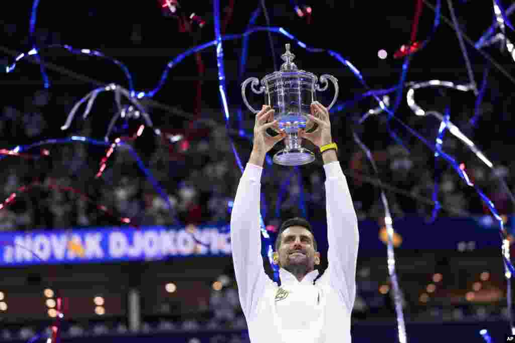 Novak Djokovic of Serbia holds up the championship trophy after defeating Daniil Medvedev of Russia in the men's singles final of the U.S. Open tennis championships, Sept. 10, 2023, in New York.