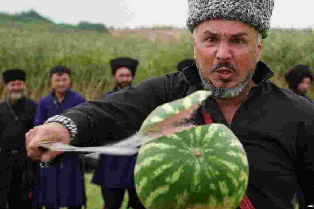 A Cossack slashes a watermelon with a sabre during a sabre-cutting competition in the village of Novosvetlovsky, Rostov region, Aug. 27, 2023.