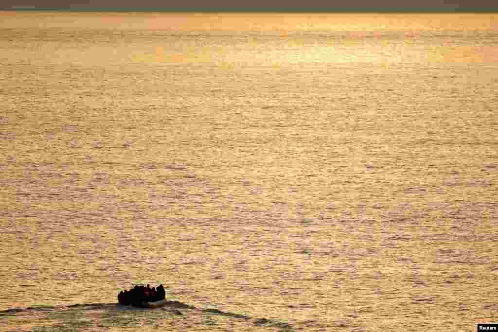 A group of migrants on an inflatable dinghy is seen during sunrise from the French rescue vessel "Abeille Normandie" as they try to cross the English Channel from the coast of northern France, Oct. 2, 2023. 