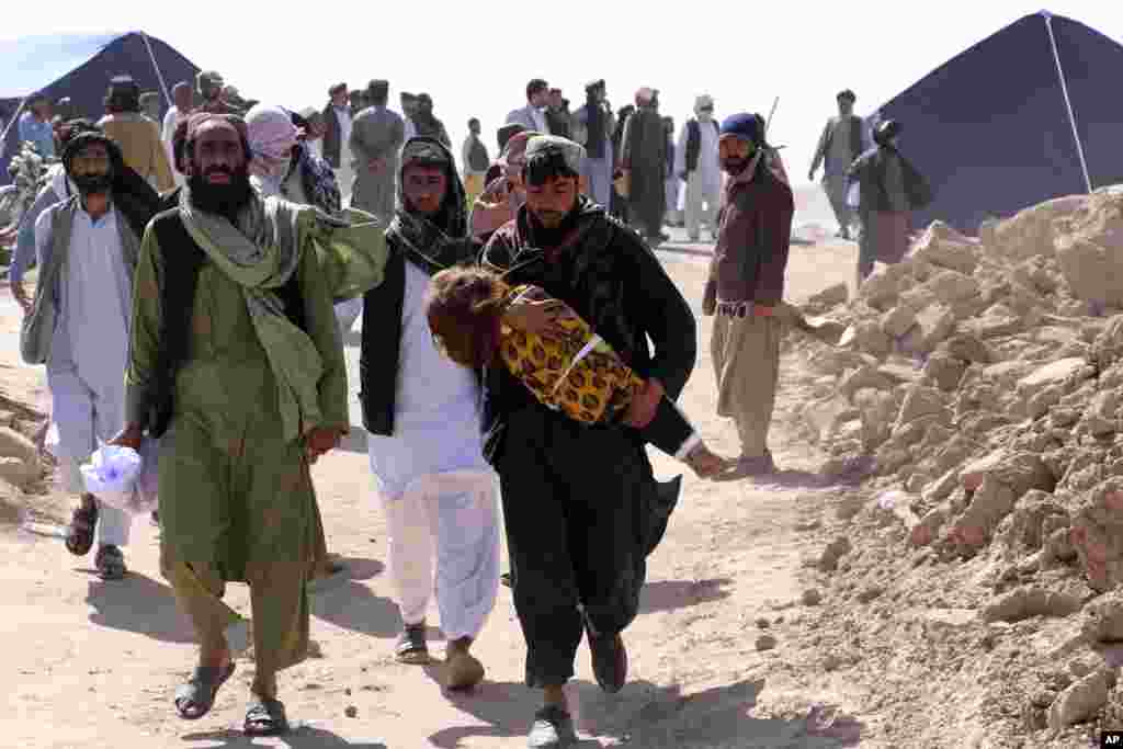 Afghans carry the body of a child after an earthquake in Zenda Jan district in Herat province of western Afghanistan. Powerful earthquakes killed at least 2,000 people in western Afghanistan, a Taliban government spokesman said. 