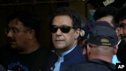 Mantan Perdana Menteri Pakistan Imran Khan dikawal petugas keamanan saat tiba di pengadilan di Islamabad, Pakistan, 12 Mei 2023. (Foto: AP)