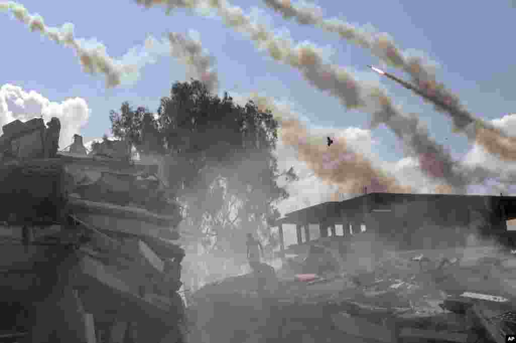 Rockets are fired from the Gaza Strip toward Israel over destroyed buildings following Israeli airstrikes on Gaza City, central Gaza Strip.