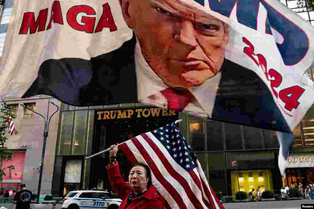 A supporter of former U.S. President Donald Trump holds up a U.S. national flag at Trump Tower in New York City, Oct. 1, 2023.