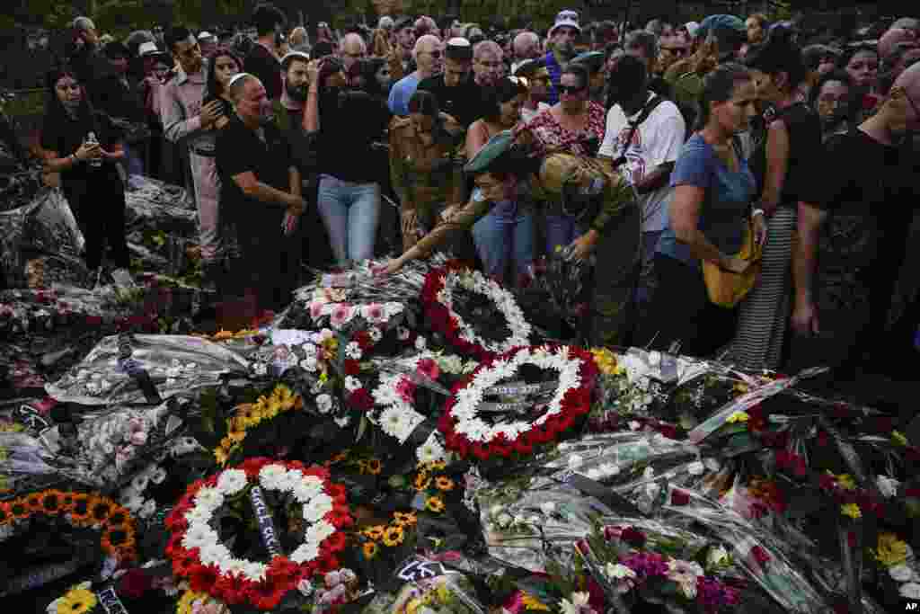 Mourners gather around the graves of Sgt. Yam Goldstein and her father, Nadav, during their funeral in Kibbutz Shefayim, Israel. Yam and her father were killed by Hamas militants at their house on Oct. 7. 