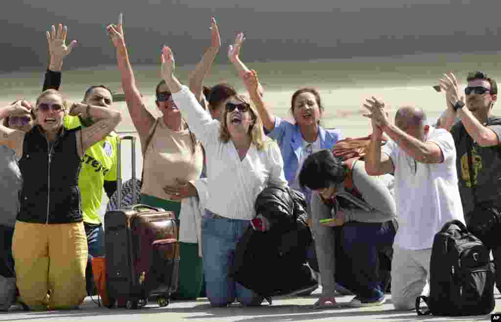 Brazilians who were caught in the latest Israel-Palestinian war kneel down on the tarmac upon their arrival at theair base in Rio de Janeiro, Brazil.