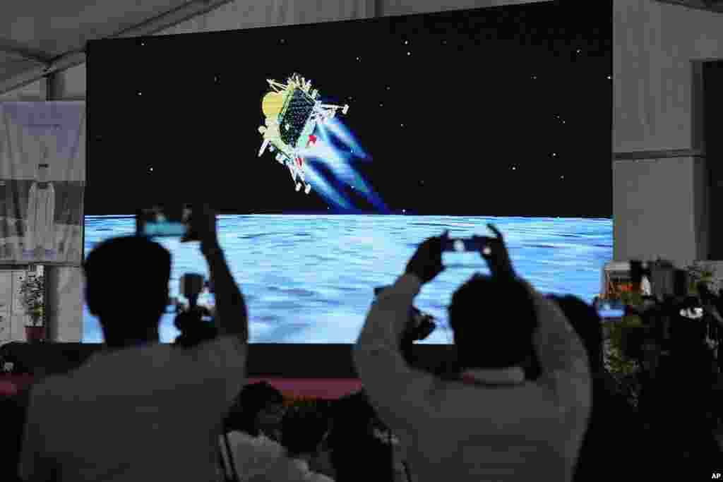 Journalists film the live telecast of spacecraft Chandrayaan-3 landing on the moon at ISRO's Telemetry, Tracking and Command Network facility in Bengaluru, India. India lands a spacecraft near the moon’s south pole, becoming the fourth country to touch down on the lunar surface.