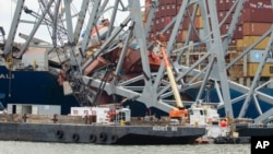 In this photo provided by the U.S. Army Corps of Engineers, salvors prepare charges for precision cuts to remove a section from the port side of the bow of the Dali container ship, during the Key Bridge Response, in Baltimore, Maryland, May 7, 2024.