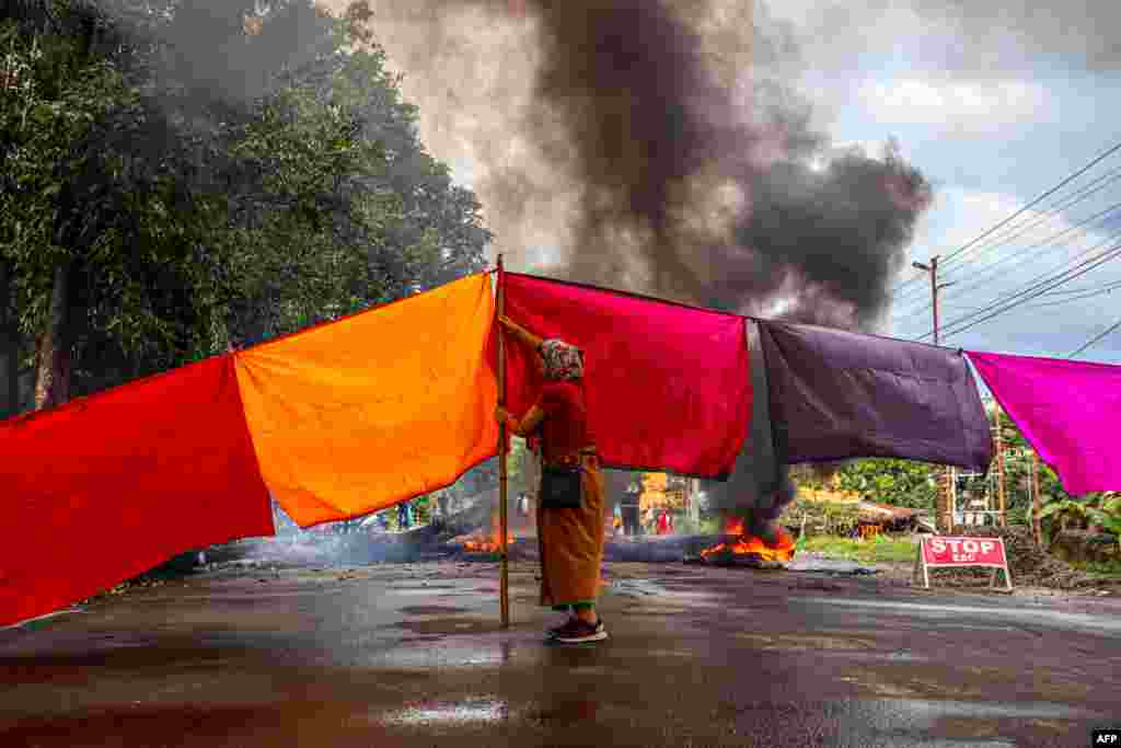 A woman protester blocks a road during 48-hour general strike in Imphal as they demand restoration of peace in India's northeastern state of Manipur after ethnic violence.