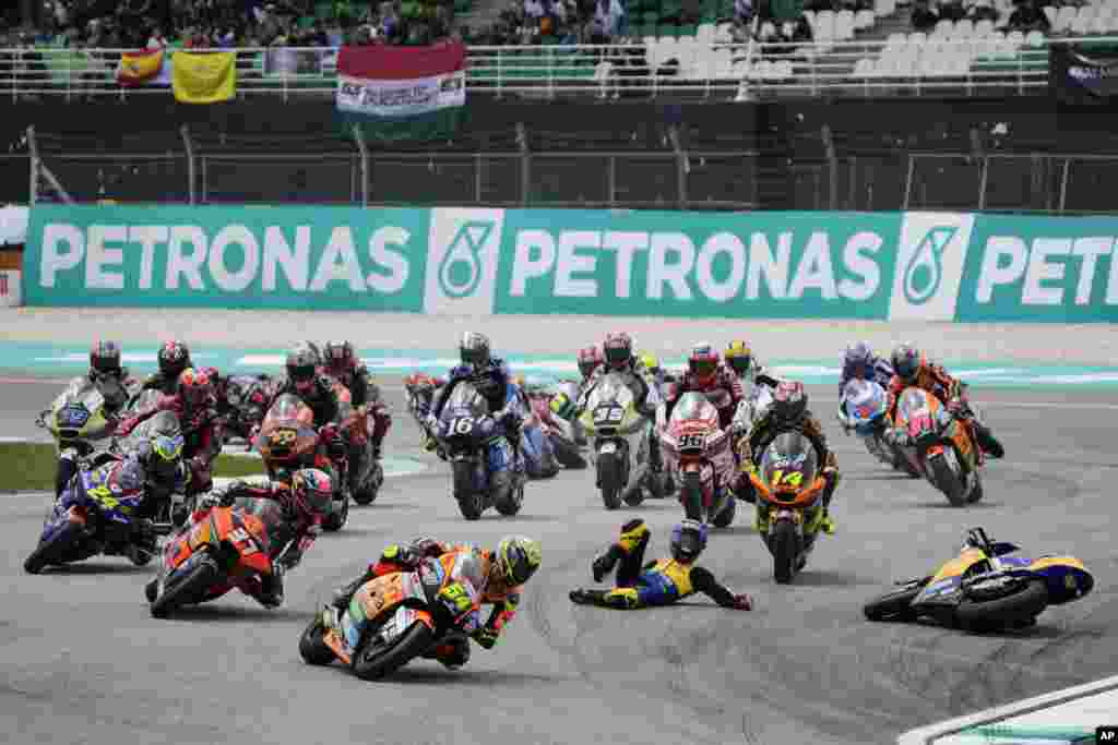 Spain's rider Fermin Aldeguer, foreground, leads as Spain's rider Manuel Gonzalez Simon falls during Moto2 class race of the MotoGP Malaysian Grand Prix at the Sepang International Circuit in Sepang, Malaysia.