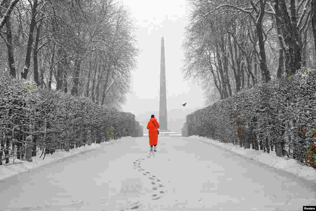 A woman walks in a snow-covered park during a first snowfall, amid Russia's attack in Ukraine, in Kyiv.