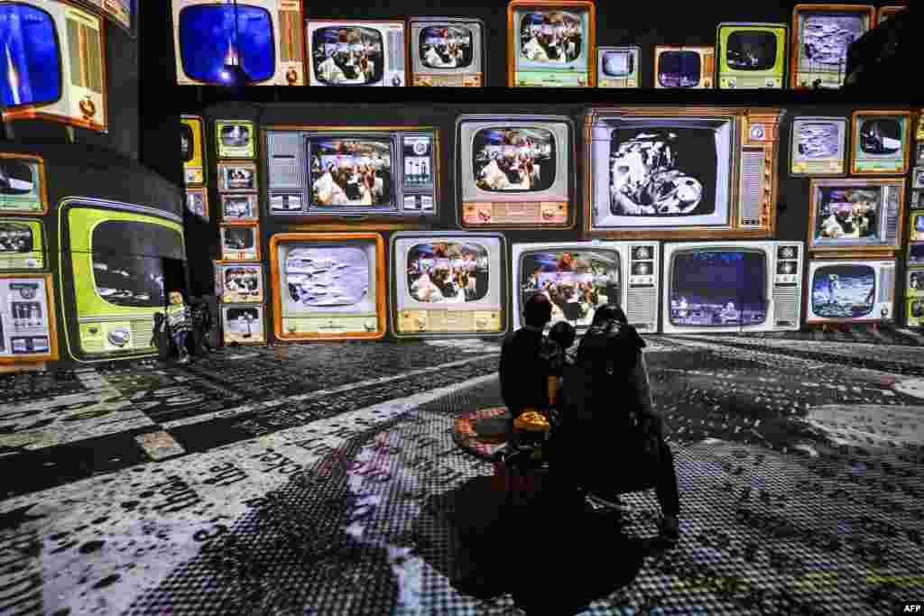 Visitors look at the new digital exhibition 'Destination Cosmos - An Infinite Journey' at the former gas plant Phoenix West in Dortmund, western Germany.