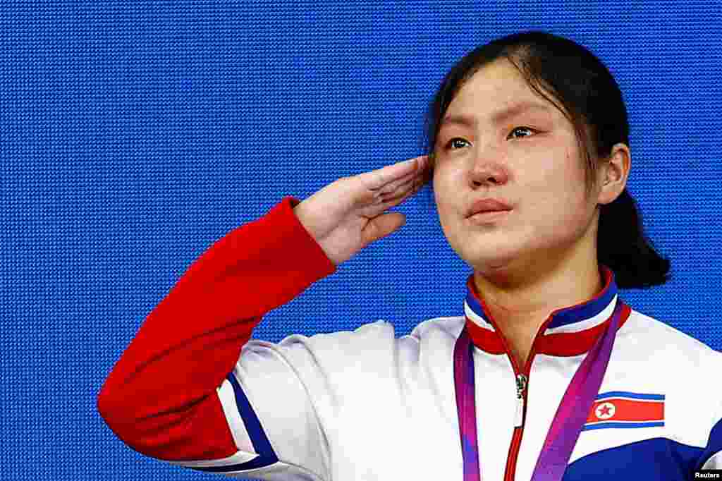 North Korea's gold medalist Kim Ilgyong salutes during the medal ceremony of the women's 59Kg Group A weightlifting of the 19th Asian Games in Hangzhou, China.