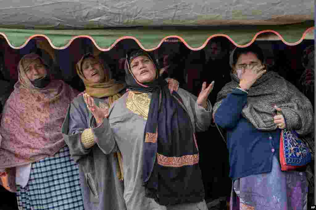 Unidentified relatives wail during the funeral procession of police officer Masroor Ahmad Wani in Srinagar, Indian controlled Kashmir. Wani was wounded when suspected rebels shot at him while he was playing cricket with boys in his neighborhood in October. 