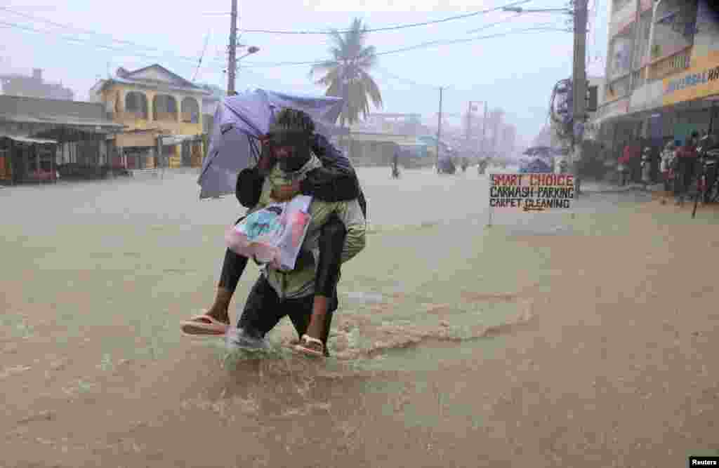 A man wades through flood waters along a street following heavy rains in Kisauni district of Mombasa, Kenya.