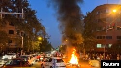 FILE - Pikipiki ya polisi ikiwaka moto wakati wa maandamano kulaani kifo cha Mahsa Amini, Tehran, Iran Sept. 19, 2022. (West Asia News Agency via Reuters)