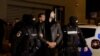 Andrew Tate and Tristan Tate are escorted by police officers outside the headquarters of the Directorate for Investigating Organized Crime and Terrorism in Bucharest (DIICOT) after being detained for 24 hours, in Bucharest, Romania, Dec. 29, 2022. 