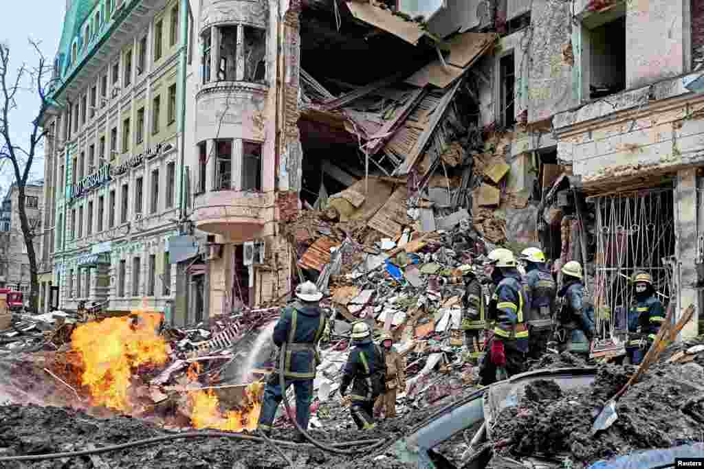 Rescuers work next to a building damaged by airstrike in central Kharkiv, as Russia's attack on Ukraine continues.