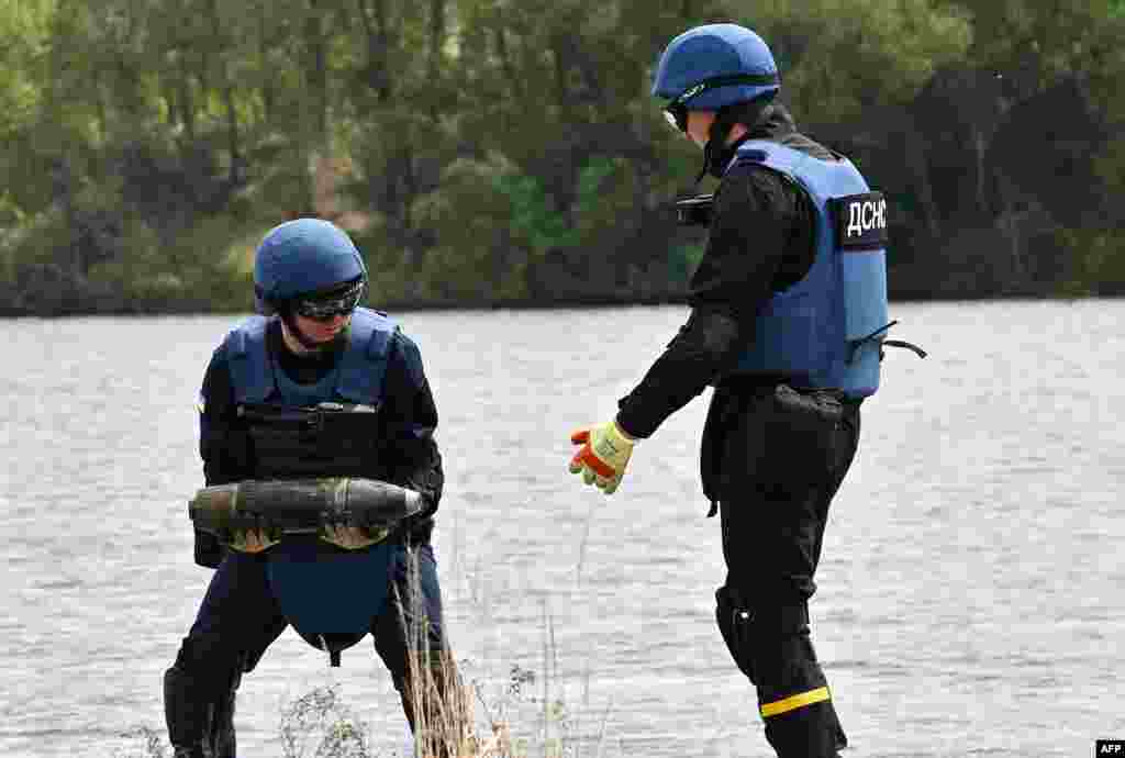 Ukrainian deminers collect unexploded material during demining works on Blue Lake in Horenka village, Kyiv region, due to the approaching bathing season.
