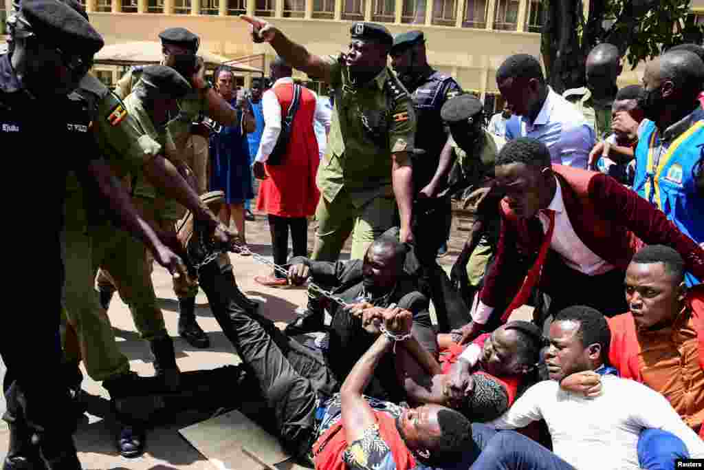 Ugandan police officers detain students marching toward parliament to protest against steep rise in the cost of commodities, in Kampala.