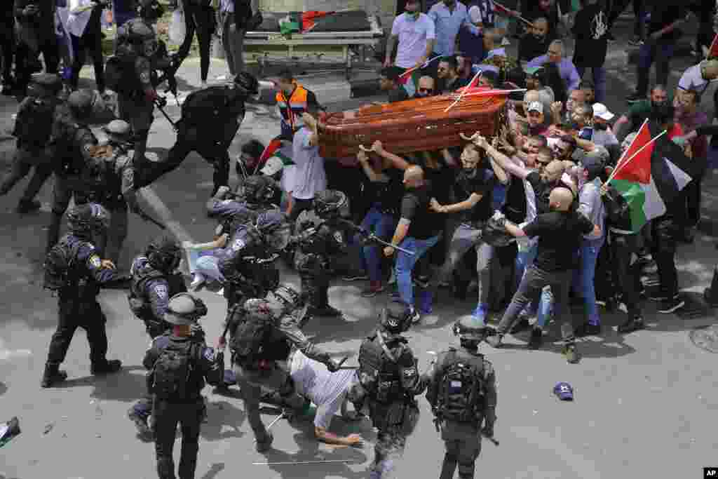 Israeli police confront mourners as they carry the casket of slain Al Jazeera veteran journalist Shireen Abu Akleh during her funeral in east Jerusalem.