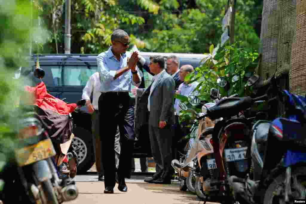 Presiden AS Barack Obama menyapa warga lokal sat berjalan kaki di Luang Prabang (7/9). (Reuters/Jonathan Ernst)