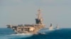 FILE - The aircraft carrier USS Abraham Lincoln, left, the air-defense destroyer HMS Defender and the guided-missile destroyer USS Farragut transit the Strait of Hormuz in this Nov. 19, 2019, photo made available by U.S. Navy. 