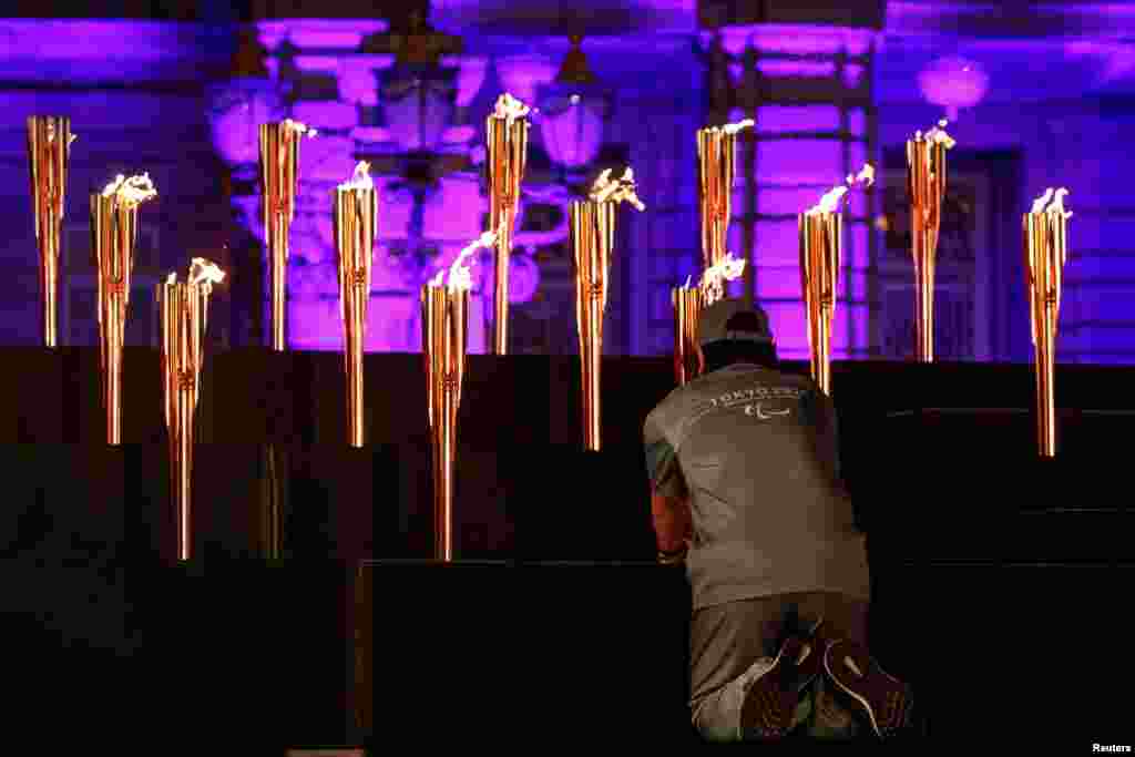 A man places a flame representing one of Japan's prefectures during the Tokyo 2020 Paralympic flame lighting ceremony at the state guest house in Tokyo, Japan.