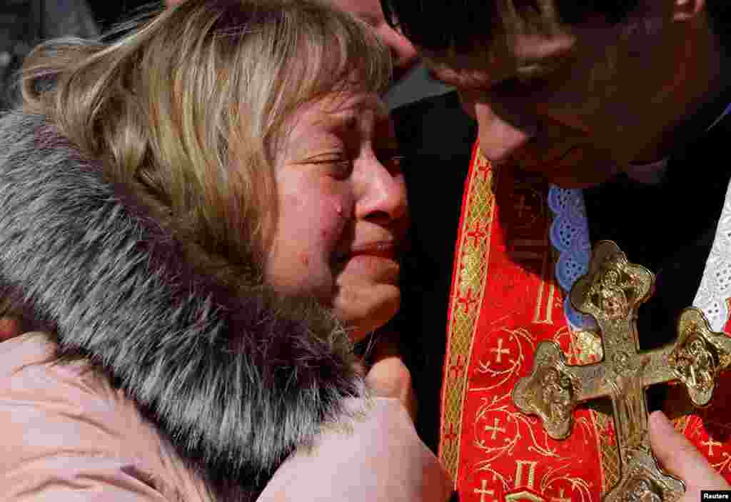 Olena, the mother of Denys Snihur, 25, a border guard-turned-soldier, killed by Russian shelling in the northern town of Ovruch, mourns her son during his funeral at the Lychakiv cemetery, in Lviv, Ukraine.