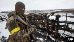 Украинский солдат на фоне сожженой российской техники