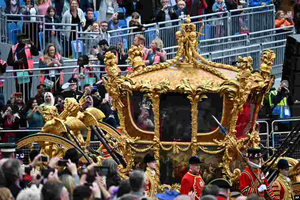 Attendees take pictures of the hologram of Britain's Queen Elizabeth II projected on the Gold State Coach during the Platinum Jubilee Pageant outside Buckingham Palace in London on the last of four days of celebrations to mark the Platinum Jubilee.