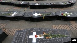 ARCHIVO - Flores sobre ataúdes simbólicos que representan a las víctimas del conflicto civil de Colombia en la plaza Bolívar en Bogotá, en abril de 2018.