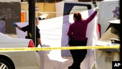 Se usa una sábana para bloquear la vista mientras el cuerpo de una de las víctimas asesinadas en un tiroteo masivo se carga en una camioneta forense en Sacramento, California, el 3 de abril de 2022. (Foto AP / Rich Pedroncelli)
